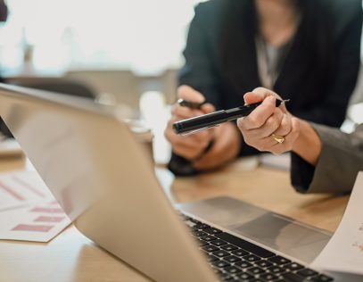 Cropped shot of business analyzing financial data, stock market information on laptop at office